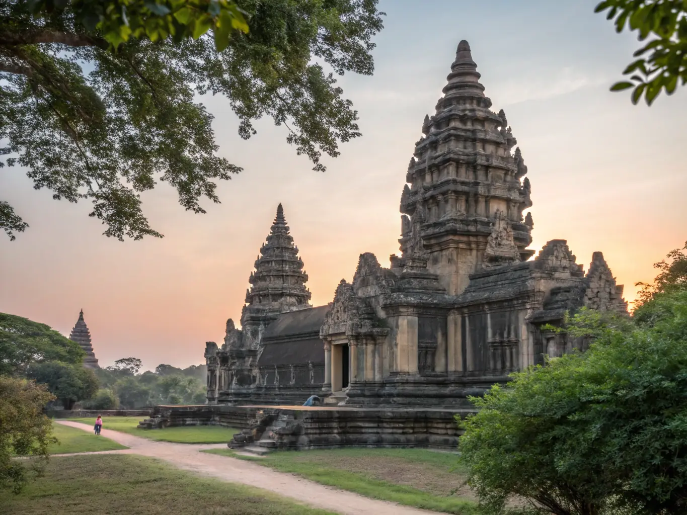The ancient temple complex of Angkor Wat in Cambodia, bathed in the golden light of sunrise. The intricate carvings and towering spires of the temple are reflected in the surrounding moat.